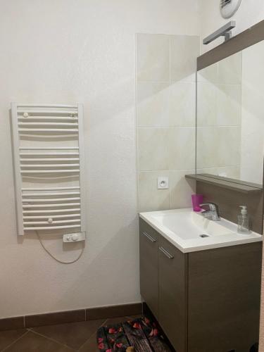 ein Bad mit einem Waschbecken und einem Spiegel in der Unterkunft Appartement meublé in Montpellier