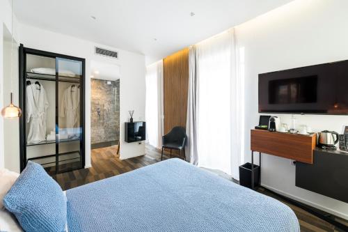 a hotel room with a blue bed and a television at HOTIDAY Room Collection - Olbia Wallure in Olbia