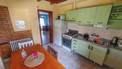 a kitchen with a wooden table and a dining room at Achalay Houses in San Carlos de Bariloche
