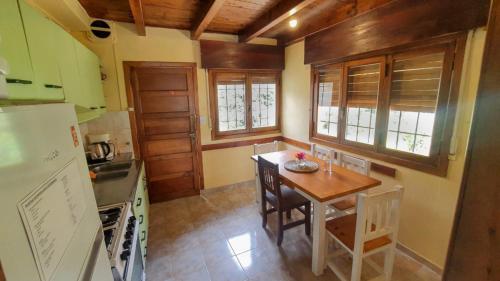 a kitchen with a small table and a refrigerator at Achalay Houses in San Carlos de Bariloche
