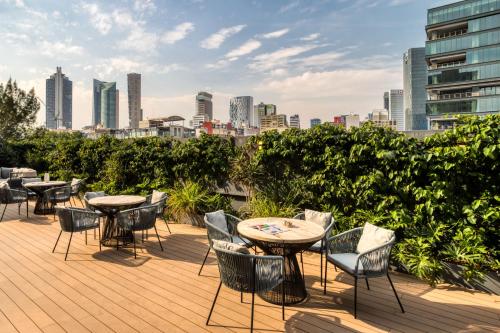 a patio with tables and chairs and a city skyline at ULIV Cibeles in Mexico City