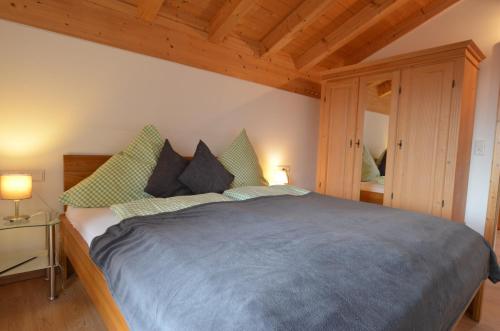 a bedroom with a large bed in a room at Feriendorf Via Claudia Haus 62 Bernhard in Lechbruck