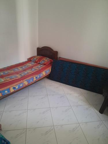 a bedroom with a bed and a tiled floor at Bouznika in Aïn Harrouda
