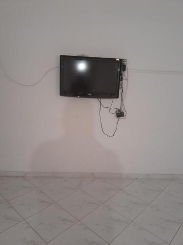 a television hanging on a white wall at Bouznika in Aïn Harrouda