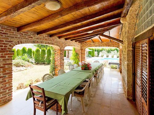 een groene tafel en stoelen in een bakstenen gebouw bij Villa Zilda in Barat