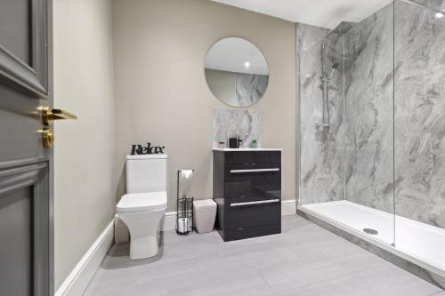 een badkamer met een toilet, een wastafel en een spiegel bij WhiskAwayStays - Victoria House - Apartment 5 in Worcester