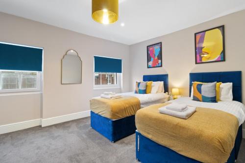 twee bedden in een kamer met blauw en wit bij WhiskAwayStays - Victoria House - Apartment 5 in Worcester