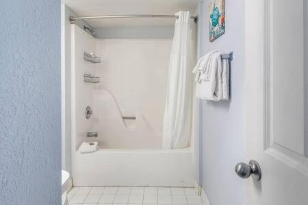 a white bathroom with a tub and a shower at Salt Pond Hideaway 133 by Brightwild in Key West