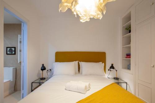 um quarto com uma grande cama branca e um cobertor amarelo em Coqueto apartamento, céntrico, con garaje y piscina by Prishomes em Vigo