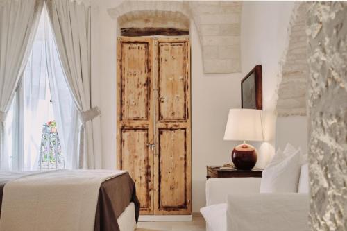 a bedroom with a wooden door and a window at 1783 Dimora d'Epoca in Locorotondo