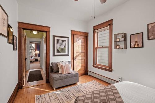 een slaapkamer met een bed, een stoel en een raam bij Charming Parisian Retreat in St Paul: 2 BR 1 bath in Saint Paul