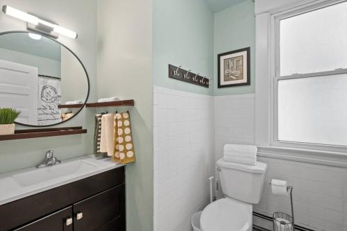 a bathroom with a toilet and a sink and a window at Charming Parisian Retreat in St Paul: 2 BR 1 bath in Saint Paul