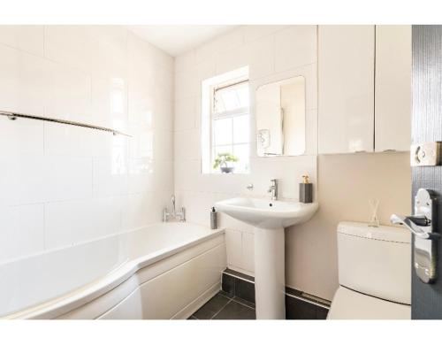 uma casa de banho branca com um lavatório e uma banheira em T'house in wigan em Pemberton