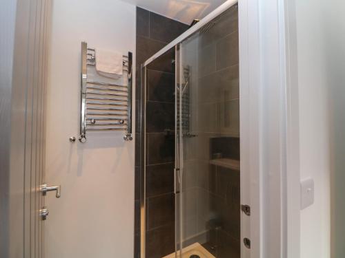 a bathroom with a shower with a glass door at Eboracum in Hathersage