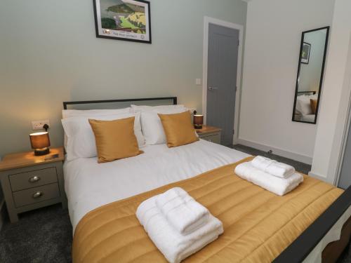 a bedroom with a large white bed with two towels on it at Eboracum in Hathersage