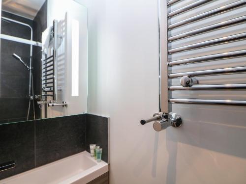 a bathroom with a tub and a sink and a mirror at Eboracum in Hathersage