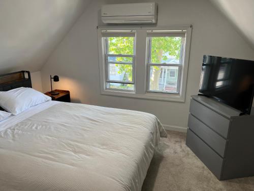 a bedroom with a bed and a flat screen tv at Modern & cozy Room in Queens near Train station and buses in Woodhaven
