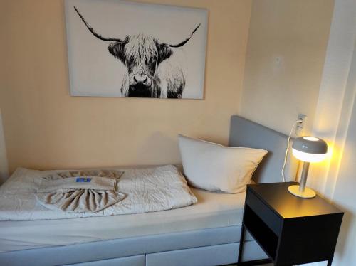 um quarto com uma cama com uma fotografia de uma vaca em MY HOME Studio, kitchen, WIFI em Chemnitz