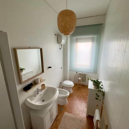 a bathroom with a sink and a toilet and a mirror at TERRA DI SUD Matera - free parking in Matera