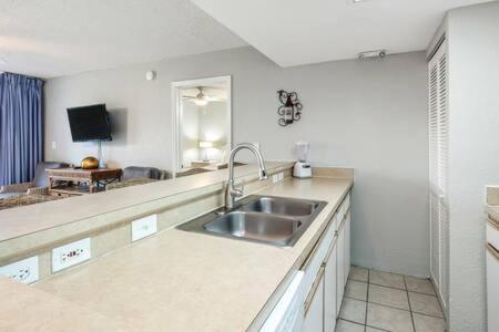 a kitchen with a sink and a living room at NEW Grenada Suite - Parking Pool & Pets 209 in Key West