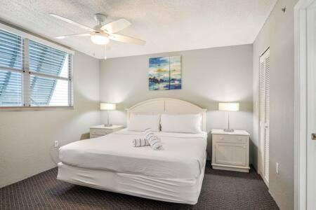 1 dormitorio blanco con 1 cama y 2 mesitas de noche en NEW Grenada Suite - Parking Pool & Pets 209 en Cayo Hueso