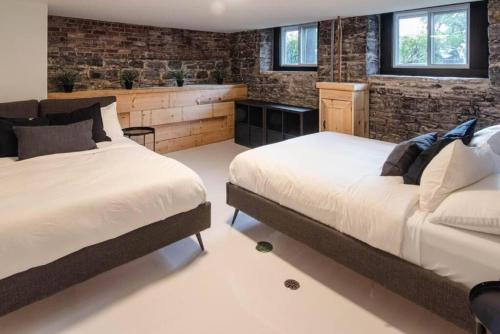 2 camas en una habitación con paredes de ladrillo en The Old New // Spacious 2000 sqft condo - Downtown en Quebec