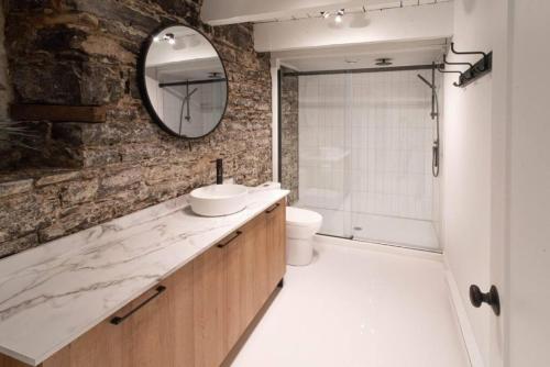 ケベック・シティーにあるThe Old New // Spacious 2000 sqft condo - Downtownの洗面台、トイレ、鏡のあるバスルーム