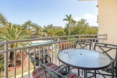 a balcony with a table and chairs and a pool at NEW Grenada Suite - Parking Pool & Pets 209 in Key West