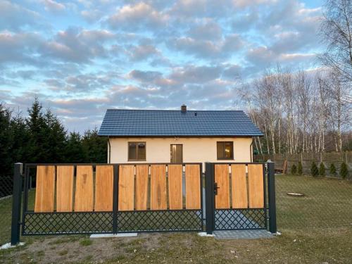 ein Haus mit einem Zaun davor in der Unterkunft SielAnka Domek letniskowy całoroczny in Orchowo