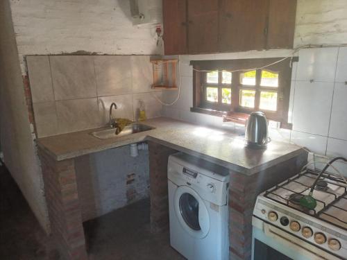a kitchen with a sink and a washing machine at RINCON SOÑADO in Paso de la Patria