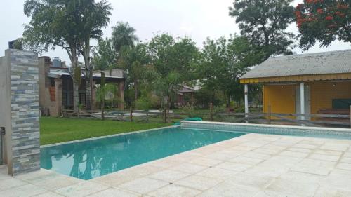 a swimming pool in a yard next to a house at RINCON SOÑADO in Paso de la Patria