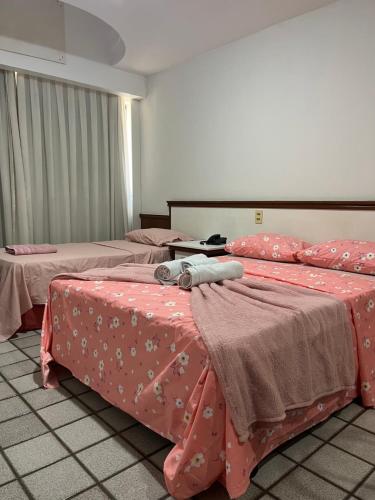 duas camas num quarto com lençóis cor-de-rosa em Apartamento com vista da praia da Costa 615 em Vila Velha