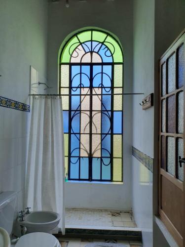a bathroom with a stained glass window and a toilet at Inocencia Faez in Roldán