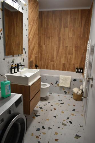 een badkamer met wastafel en wasmachine bij Save Relaxing Residence Brasov in Braşov