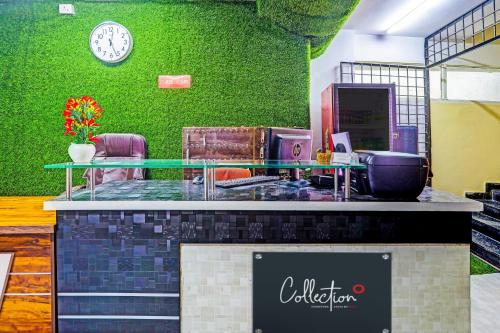 a store with a green wall with a clock on it at Hotel Saharsh Grand Near Shilparamam in Hyderabad