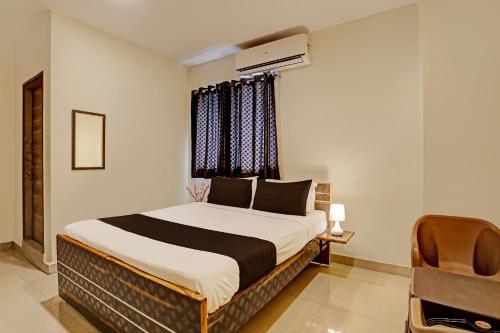a bedroom with a bed and a window at Hotel Saharsh Grand Near Shilparamam in Hyderabad