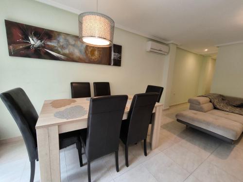 a dining room with a table and black chairs at Beach and sun guest house in Torrevieja