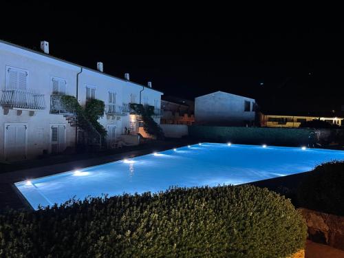 a large blue swimming pool with lights next to a building at Gardenia Luxury in Palau