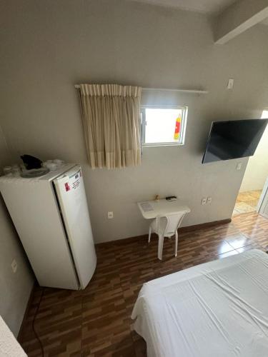 a room with a refrigerator and a table in it at Pousada da Celma in Fortaleza