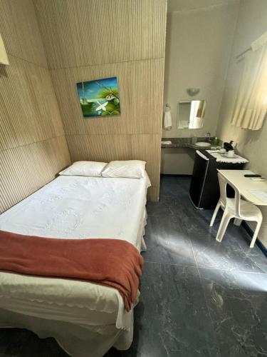 a hotel room with a bed and a desk and a kitchen at Pousada da Celma in Fortaleza