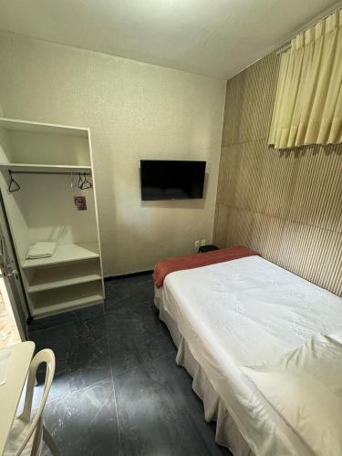 a bedroom with a large bed and a television at Pousada da Celma in Fortaleza