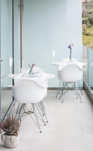two white tables and chairs on a balcony at ALKIMIA boutique hotel in Vasto