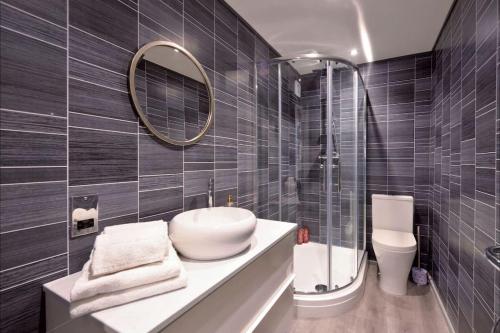 uma casa de banho com um lavatório, um espelho e um WC. em Apartment in Scottish Borders em Jedburgh