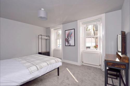 um quarto com uma cama, uma secretária e 2 janelas em Apartment in Scottish Borders em Jedburgh