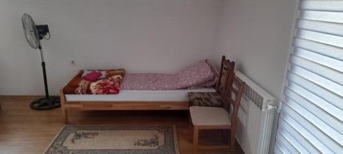 a bed in a room with a table and a chair at Aura City 2 in Visoko