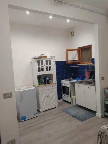 cocina con electrodomésticos blancos y azulejos azules en Il mio piccolo angolo di mare en Viareggio