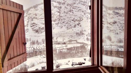 ein Fenster mit Blick auf einen schneebedeckten Berg in der Unterkunft APARTAMENt MAIANS in Soldeu