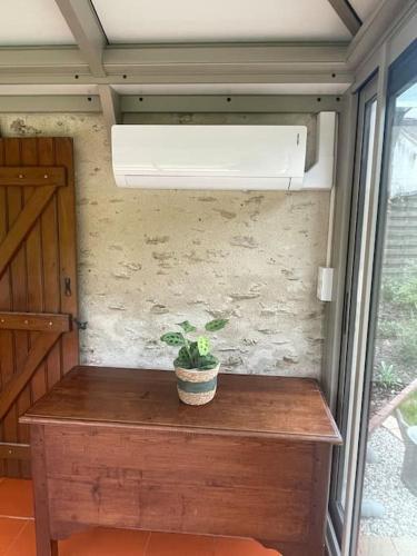 a potted plant sitting on a wooden table in a room at Gite des Terres Noires (nouveau logement) in Contres