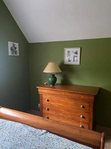 a bedroom with a wooden dresser with a lamp on it at Gite des Terres Noires (nouveau logement) in Contres