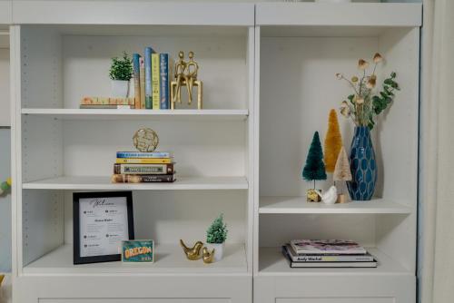 a white book shelf filled with lots of books at Bright & Cozy Modern Studio, Fast WiFi, Quiet, Walkable to University of Portland in Portland